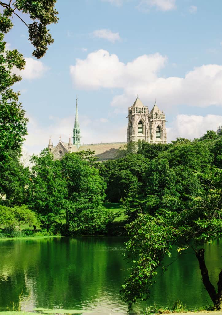 A cathedral behind a verdant lake