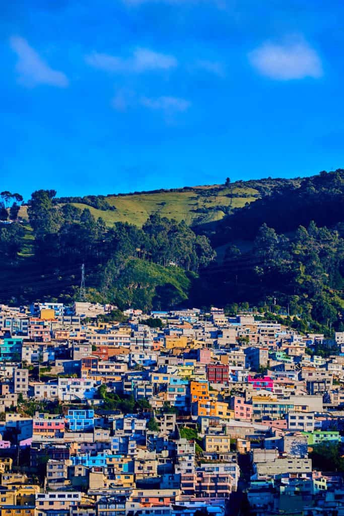 Colorful houses built into the hillsides of Quito's volcanic valley