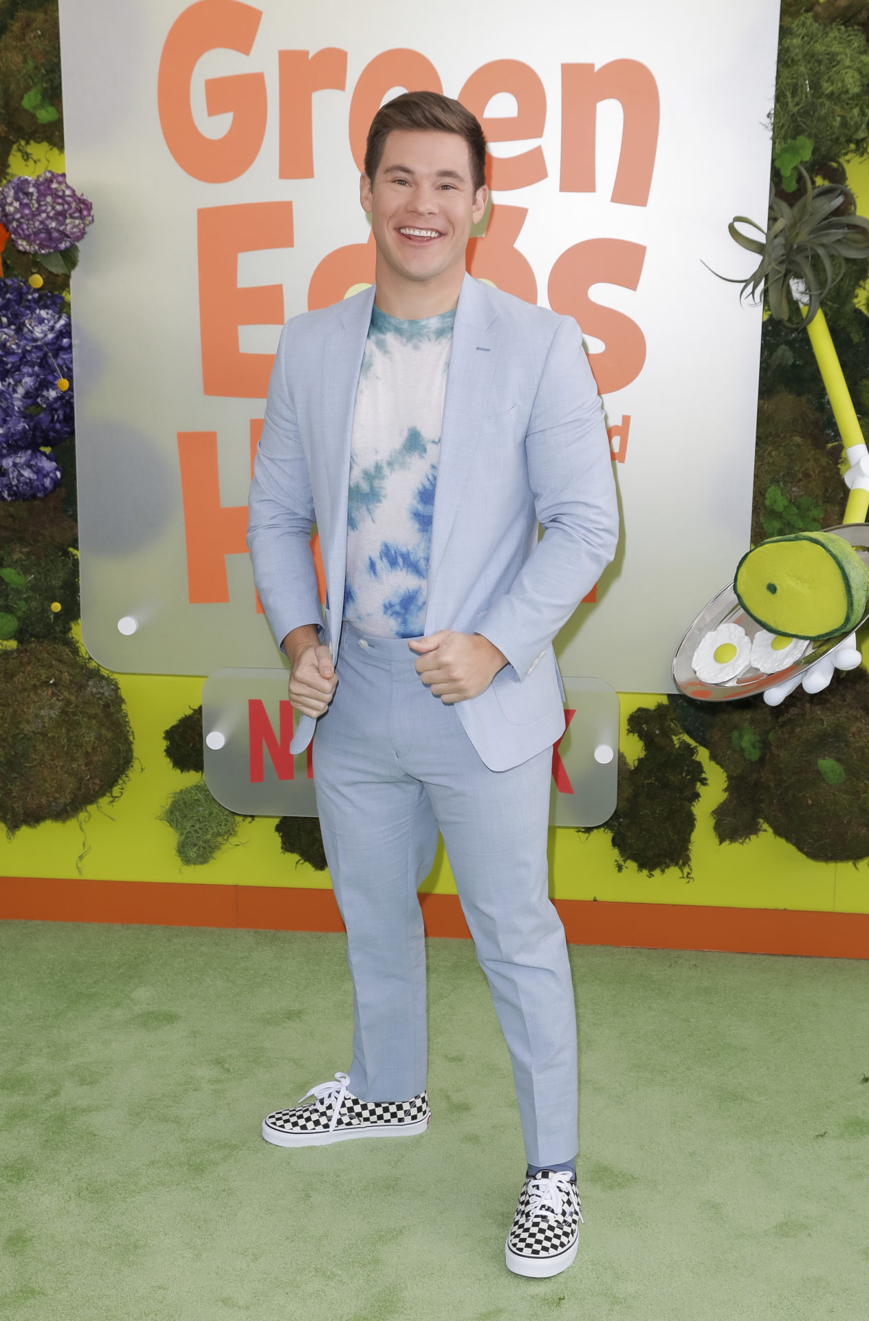 Adam Devine wearing a powder blue suit at a premiere event. 