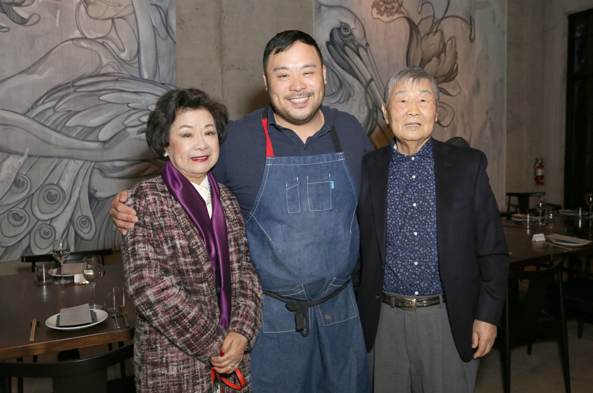 Chef David Chang standing with his parents either side of him