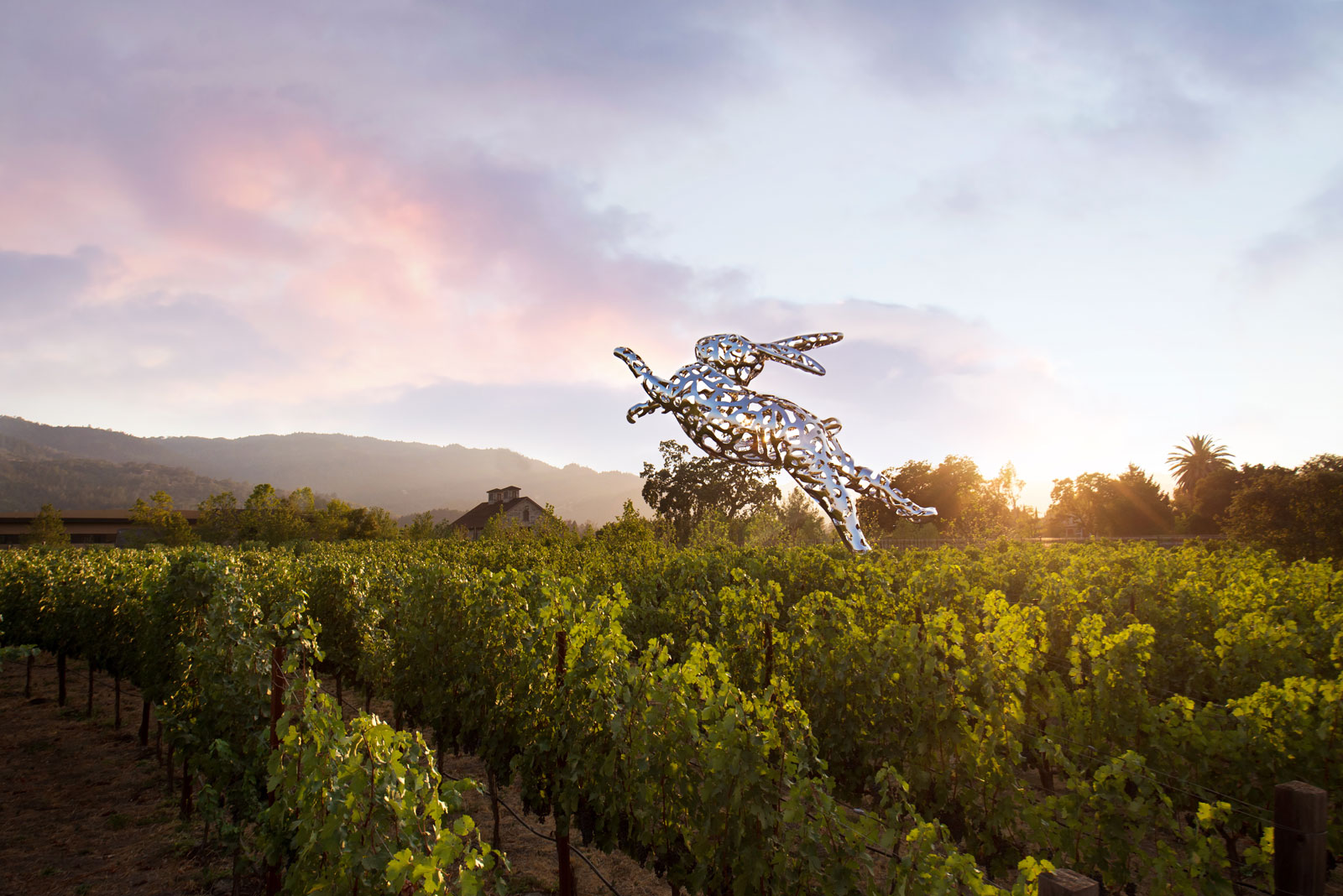 A large steel bunny leaping from a vineyard in California Wine Country. 