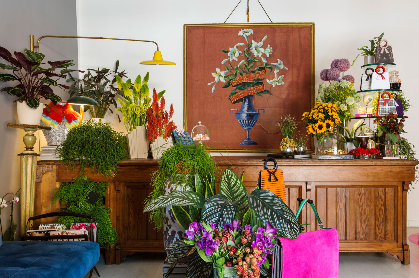 A shop space filled with plants and colourful handbags. 