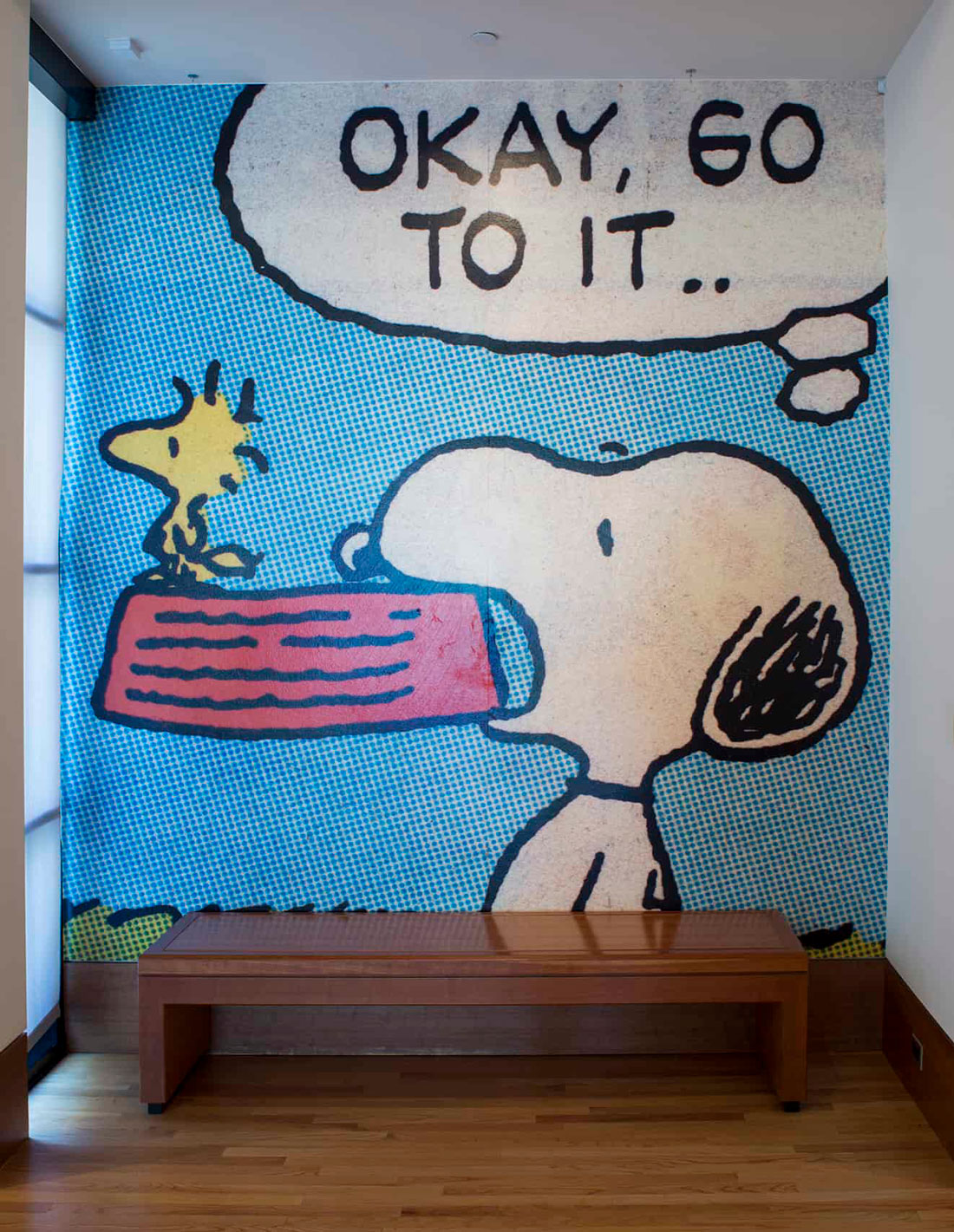 A frame from a Peanuts cartoon covering a wall. 