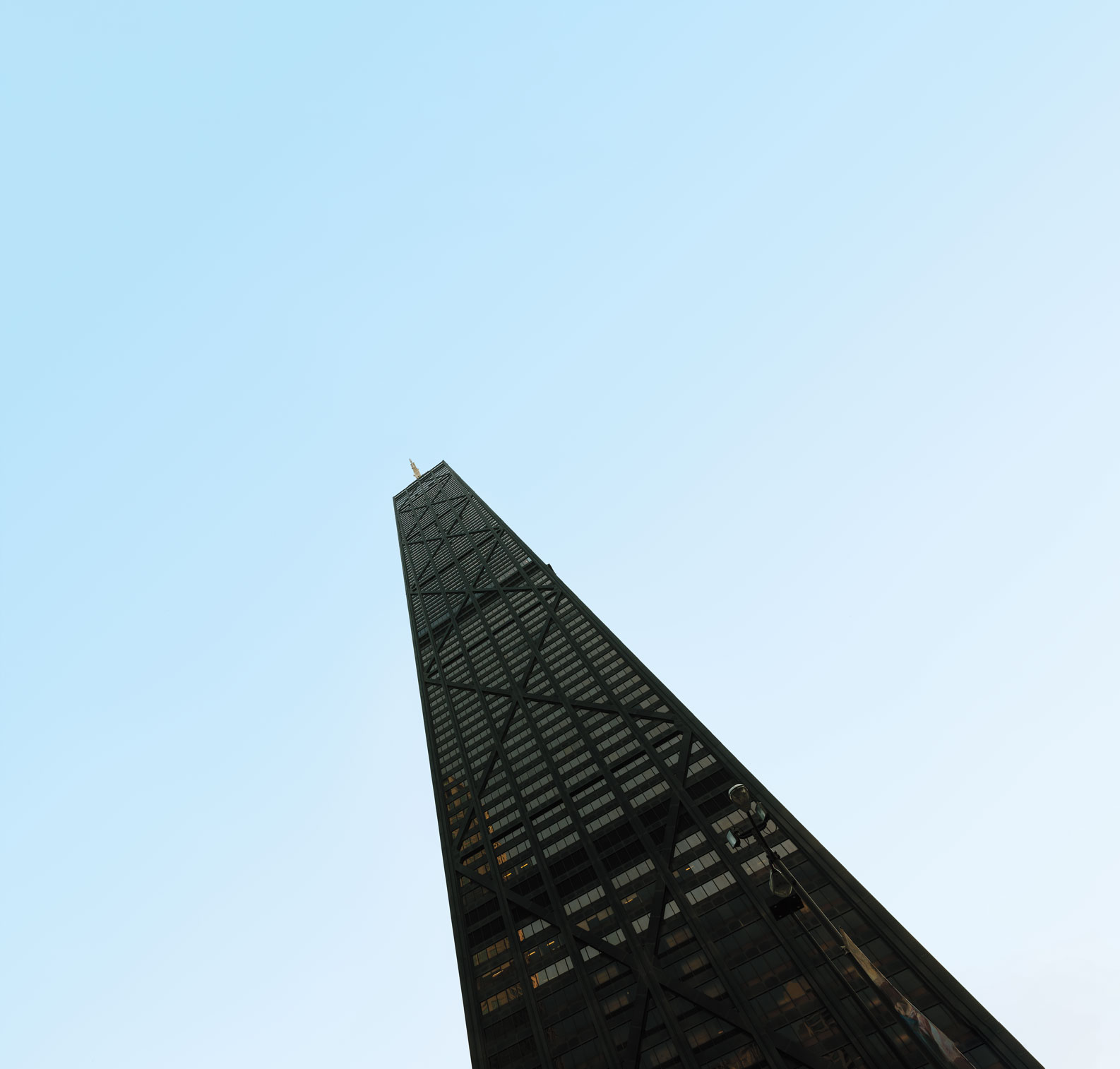 A black skyscraper against a blue sky.