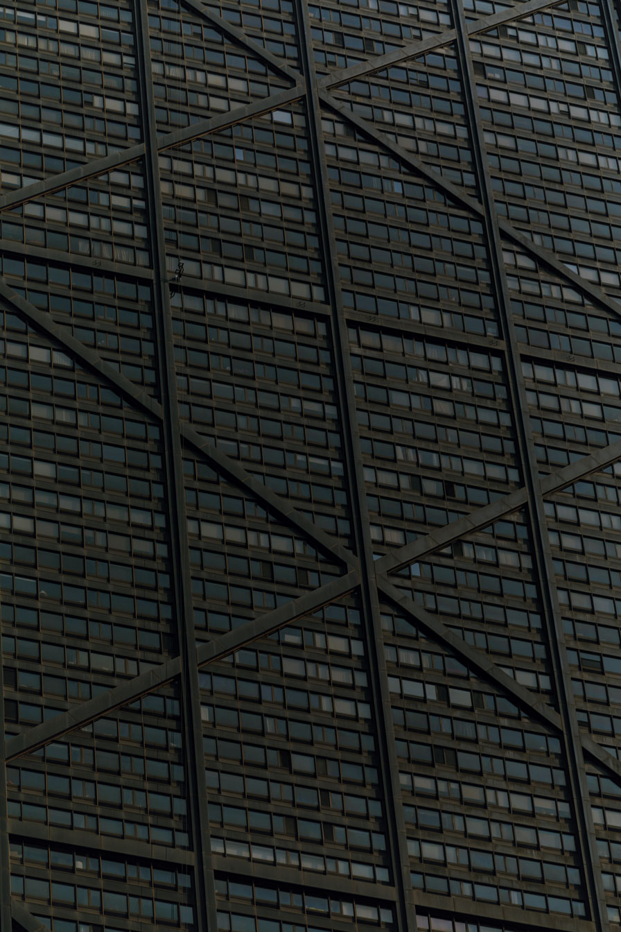 The criss cross facade of a black skyscraper. 