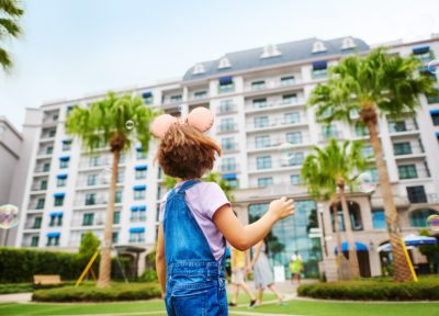 Girl with mickey mouse ears standing in front of a building