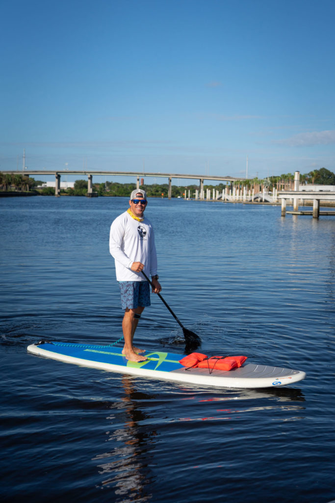 A man on a stand up paddle board.