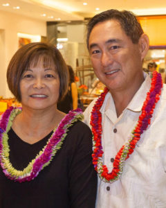a couple with hawaiian flowers around their neck