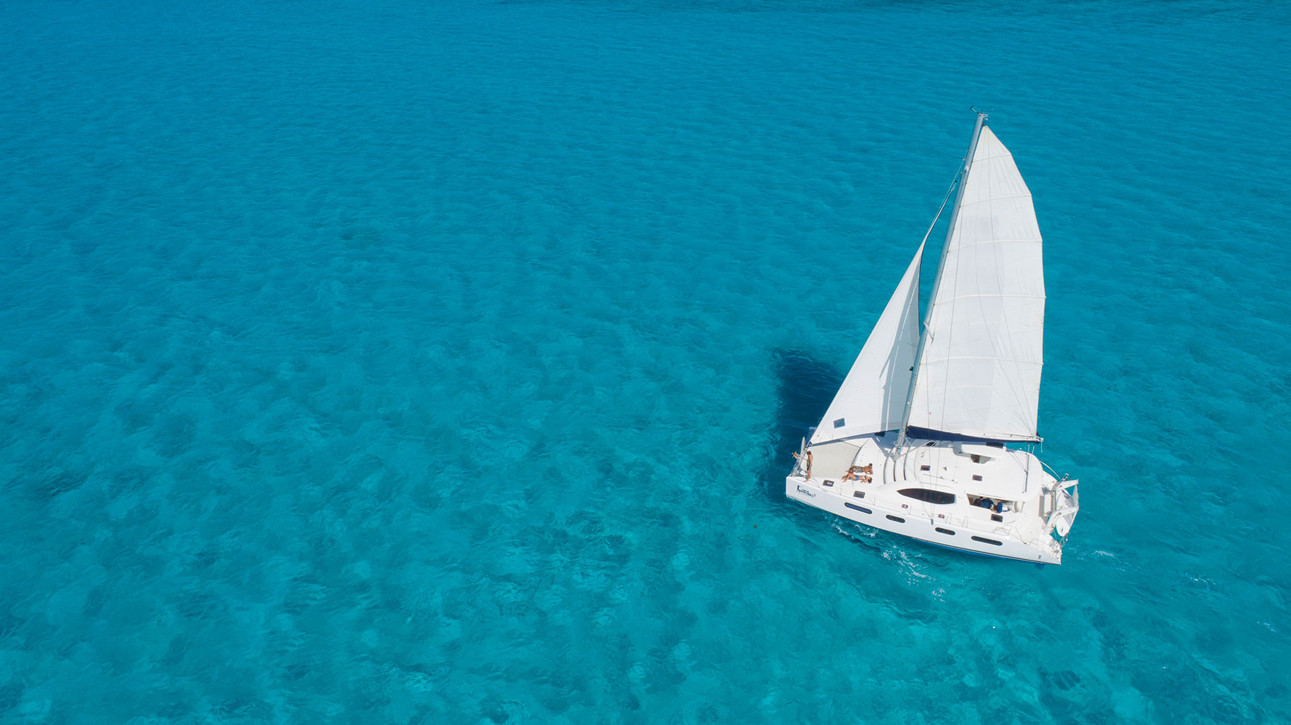 A white sailing boat on turquoise waters.
