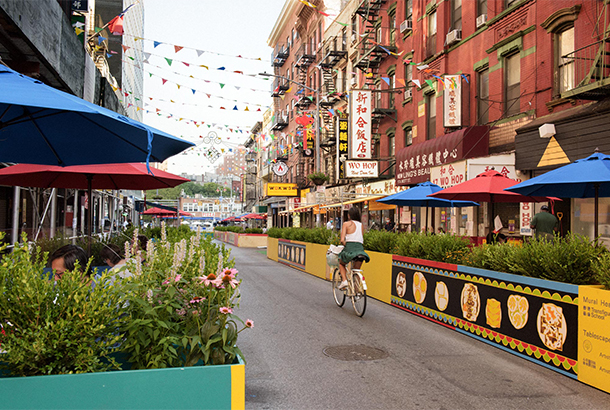 Woman riding bicycle through New York's Chinatown