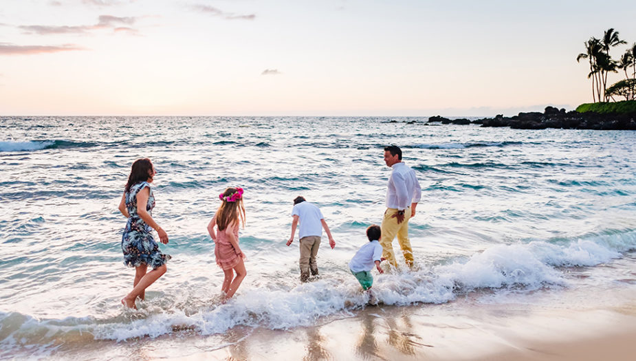 A family plays on a white sand beach