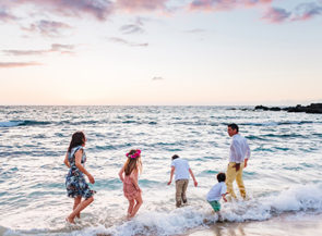 A family plays on a white sand beach
