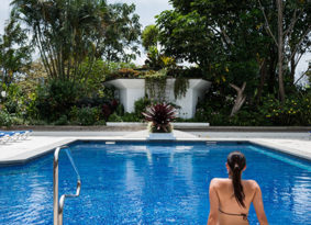 Woman sits at the foot of a pool at the Hotel Bougainvillea in Costa Rica